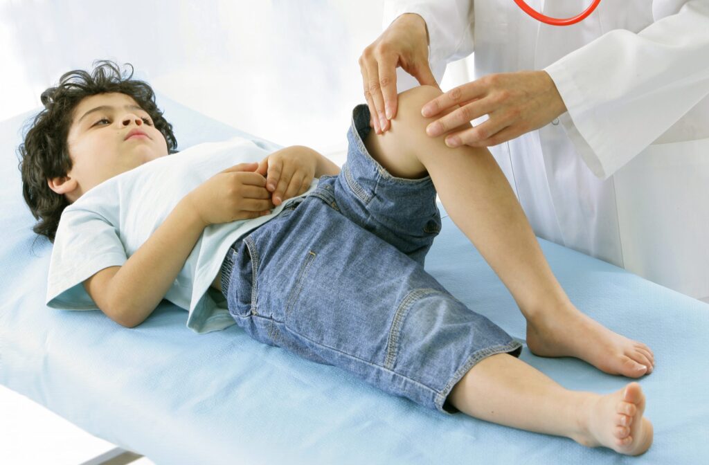 Menino tem seu joelho examinado por médico: as queixas de dores em membros são bastante comuns em crianças
