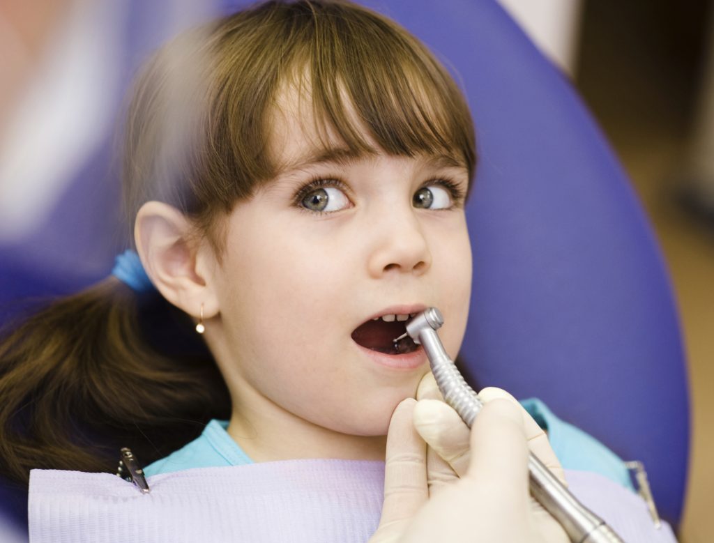 Criança na cadeira do dentista: é importante os pais ajudarem os filhos na escovação