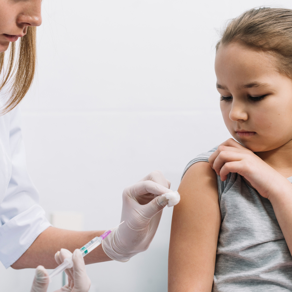 Menina toma vacina aplicada por uma enfermeira: SPB recomenda nova vacina da dengue para crianças