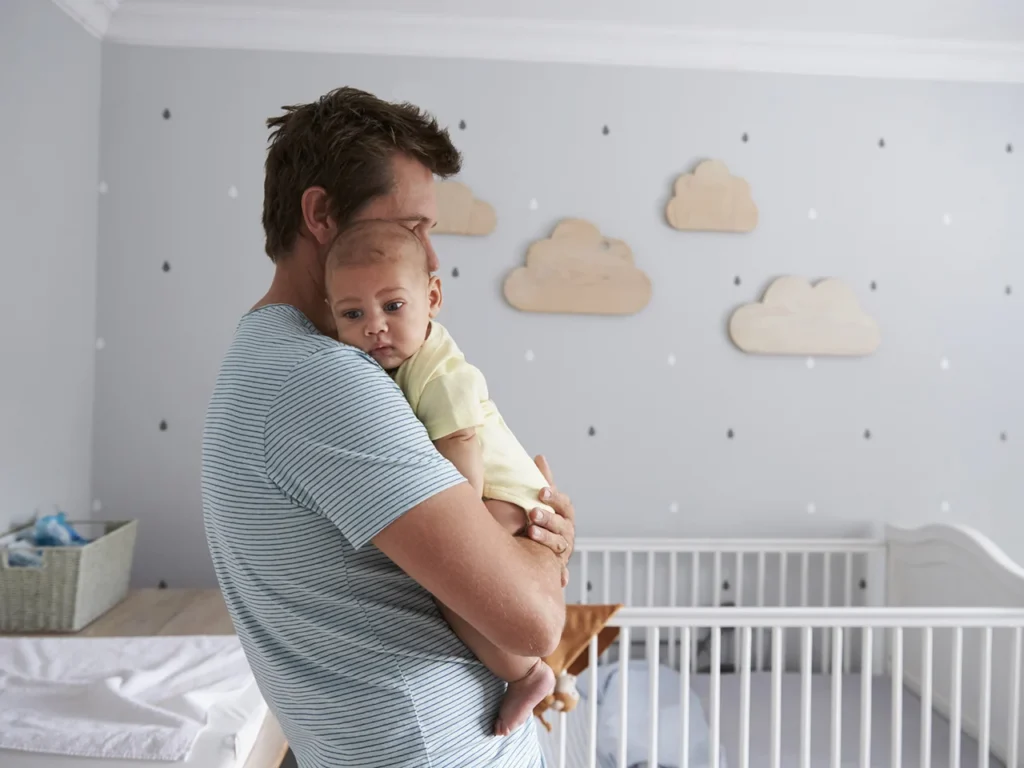 Pai segura seu bebê no colo: em seus primeiros anos de vida, um bebê passa por diversas mudanças, incríveis, tanto físicas quanto emocionais.