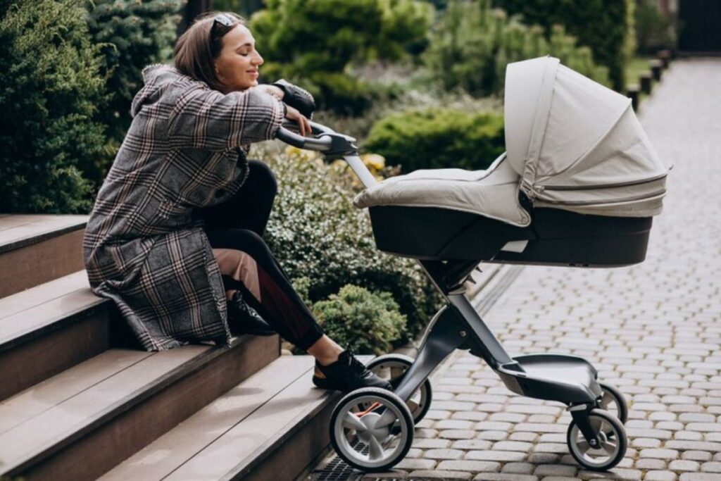 Mãe observa bebê em um carrinho: muitos pais ainda questionam qual é o momento ideal para o bebê sair de casa.
