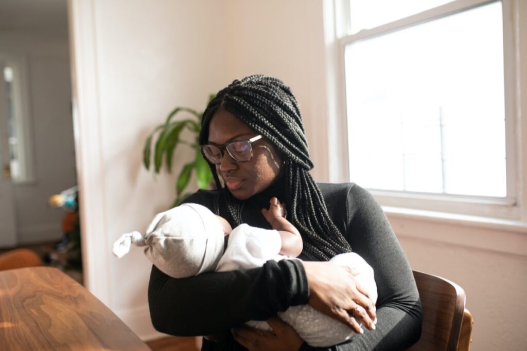 Mãe segura bebê no colo: na retomada da carreira profissional da mãe, os bebês podem sofrer. Por isso é preciso ser assertiva e prepará-los antes