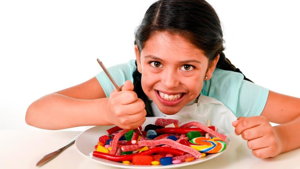 Criança sorri antes de comer doces; crianças com colesterol alto: o que fazer?